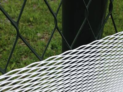 White PVC coated expanded metal fencing is installed upon a pre-existing green expanded metal fence.