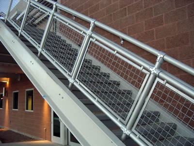Welded wire cloth stair railings with galvanized surface and square holes are applied outdoors.