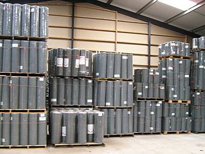 Welded wire lath panels packed in rolls, being put on wooden pallets, and stored in warehouse.