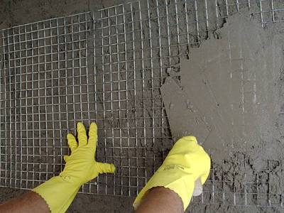 A worker with gloves is extending stucco over our self-furring welded wire lath.
